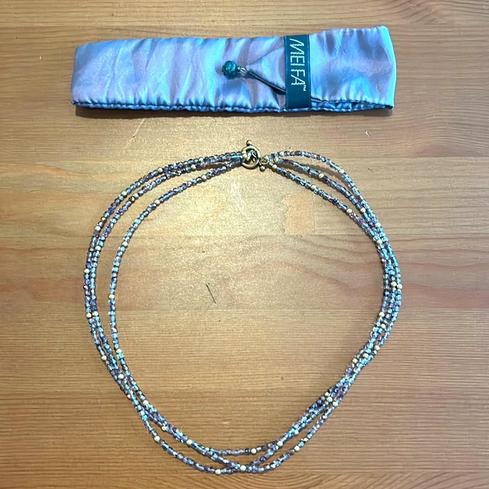 Three strand purple and gold beaded necklace with pouch.